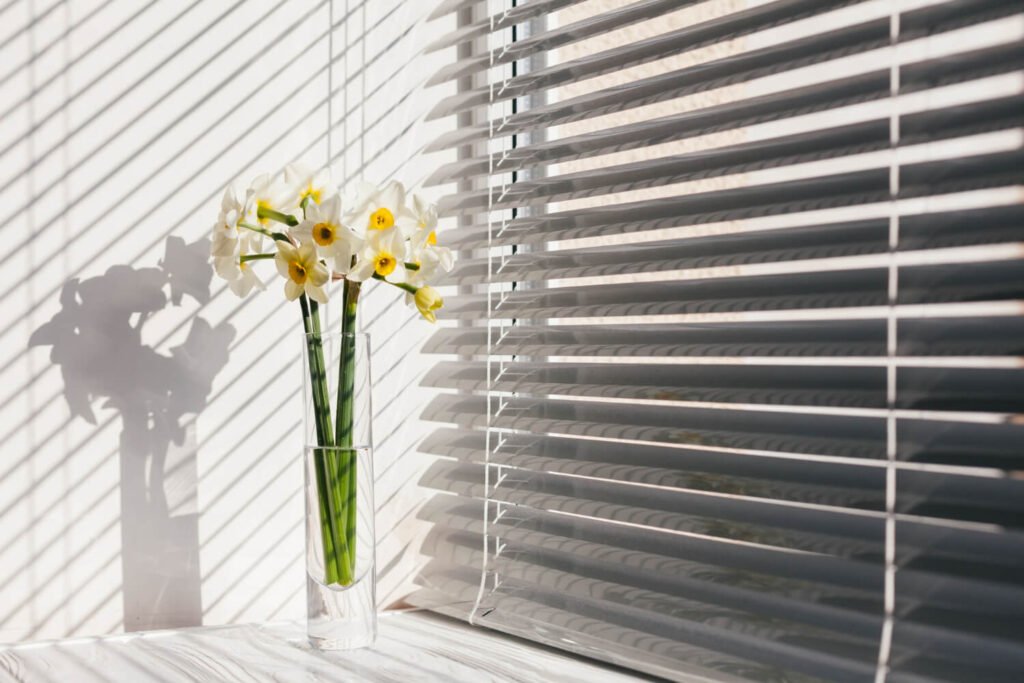 Persiana de PVC junto a una planta de decoración